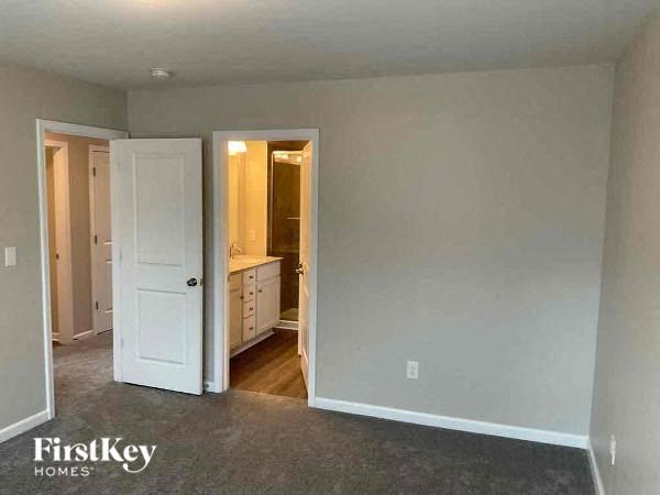 A room with a white door and a carpeted floor.