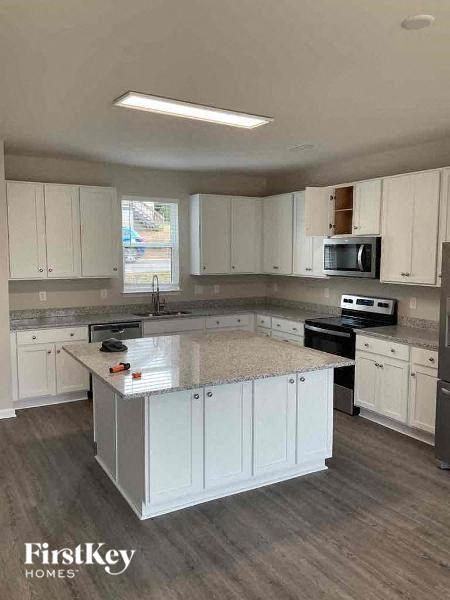 A kitchen with white cabinets and a granite countertop.
