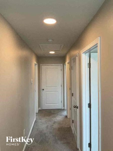 A long hallway with white doors and a FirstKey Homes logo.