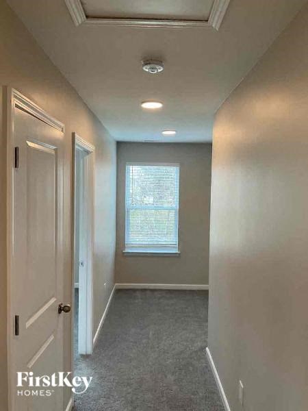 A hallway with a door on the left and a window on the right.