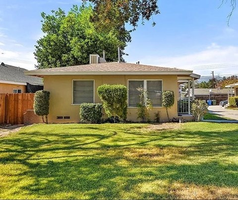 a small house with a yard and a fence