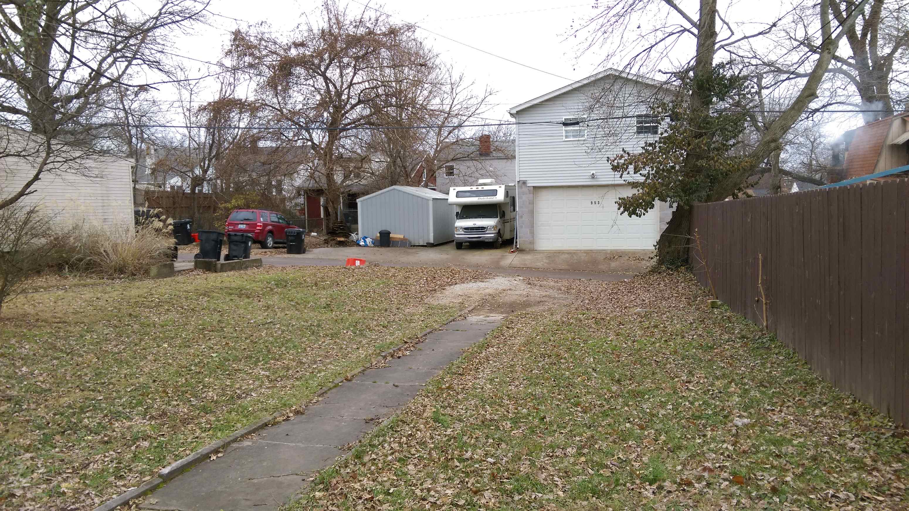 a yard with a house and a truck parked in the driveway
