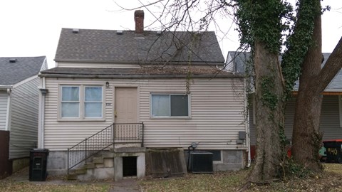 a white house with a yard and a tree