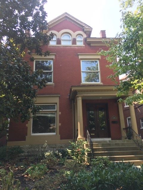 a red brick house with a front porch and stairs