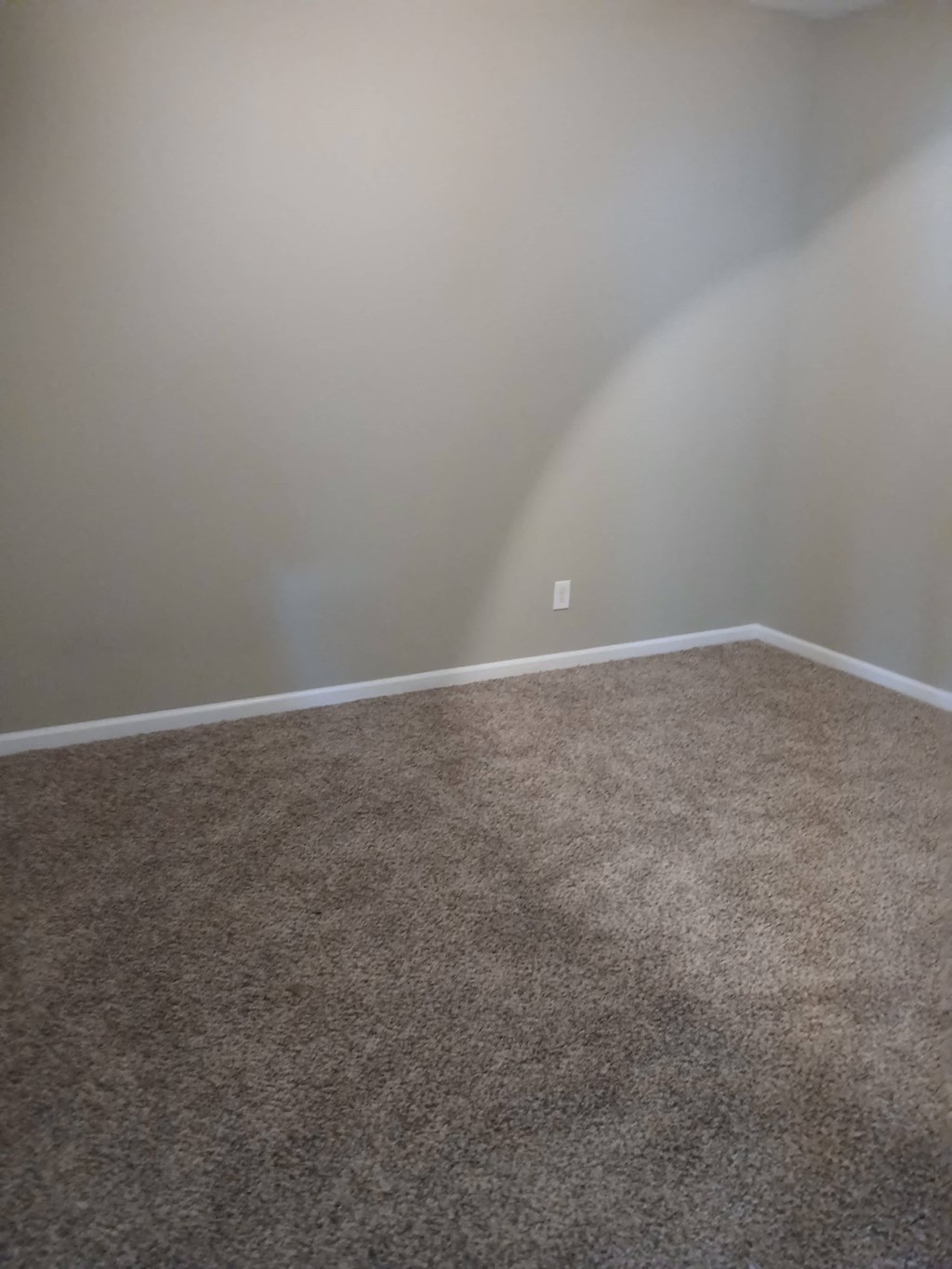 a room with a carpeted floor and a white wall