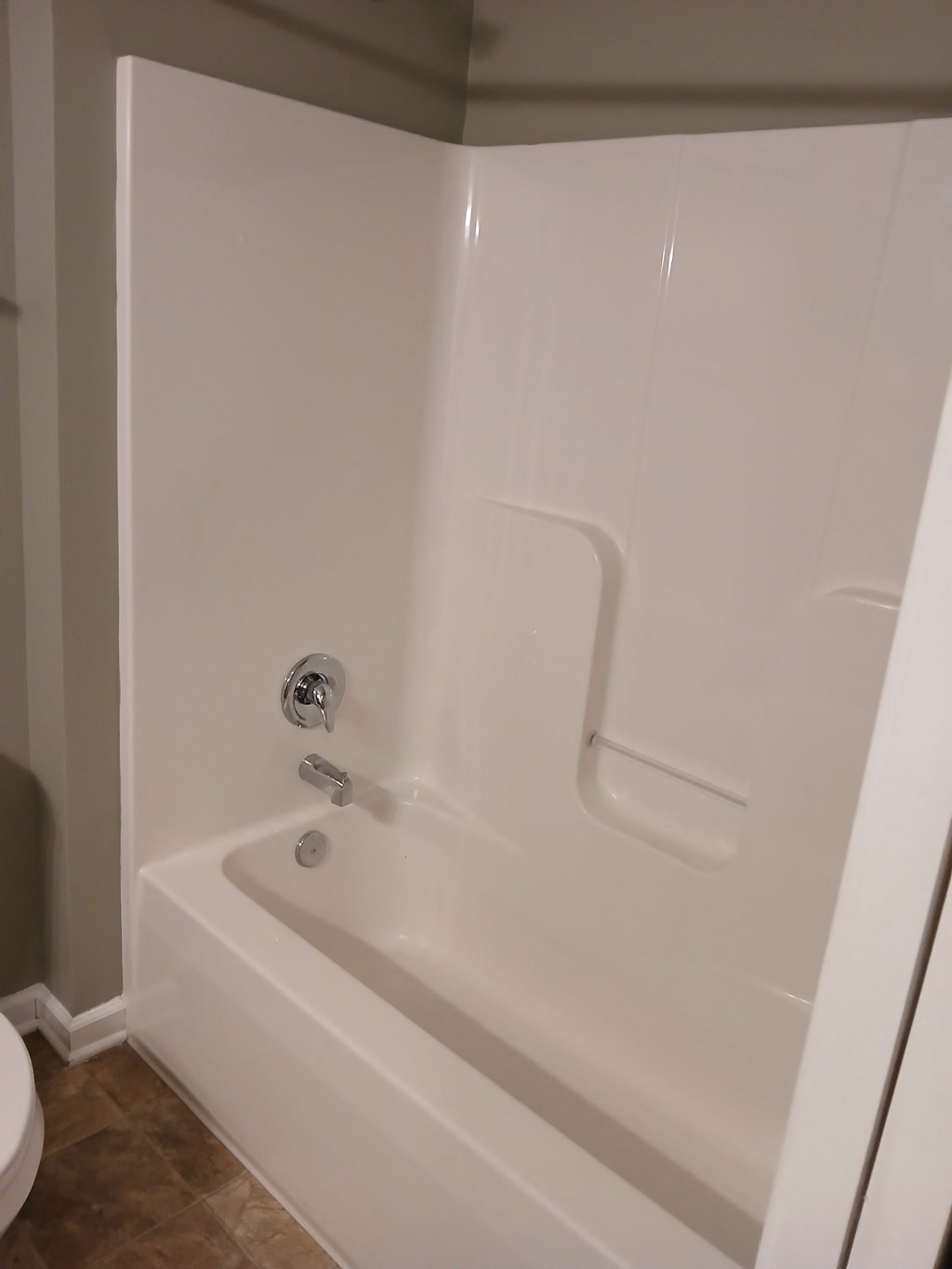 a white bath tub in a bathroom with a toilet
