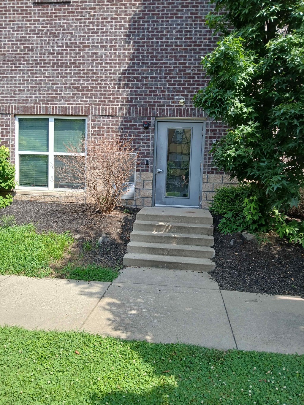 a brick building with a blue door and stairs in front of it