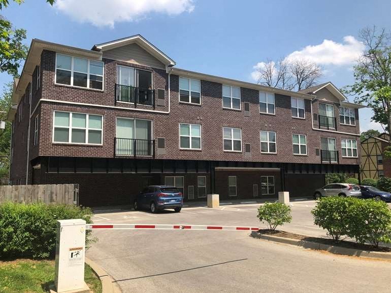 a brick apartment building with a car parked in front