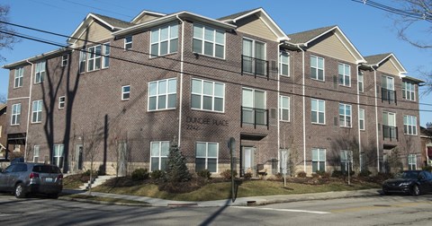 a brick apartment building with cars parked in front