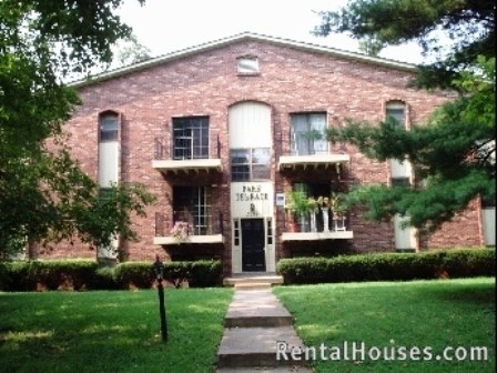 a red brick house with a black door and a lawn