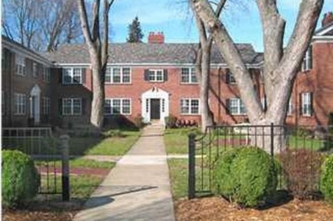 A red brick building with a white door and windows.