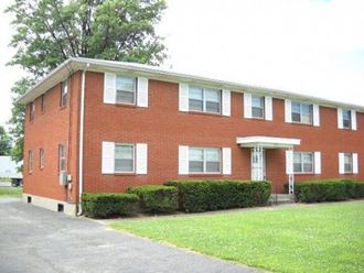 a red brick building with bushes in front of it