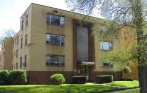 an apartment building with a lawn in front of it