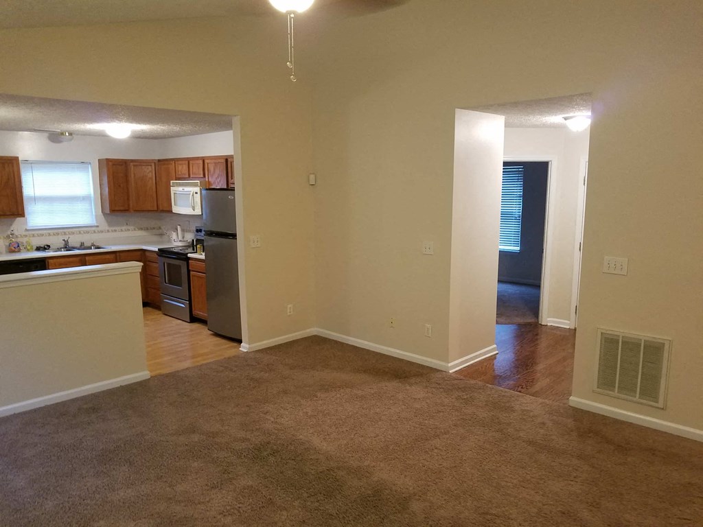 an empty room with a kitchen and a living room