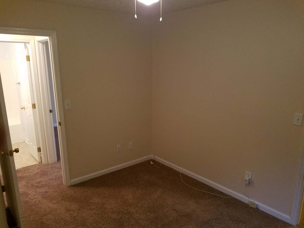 a empty room with beige walls and a white door