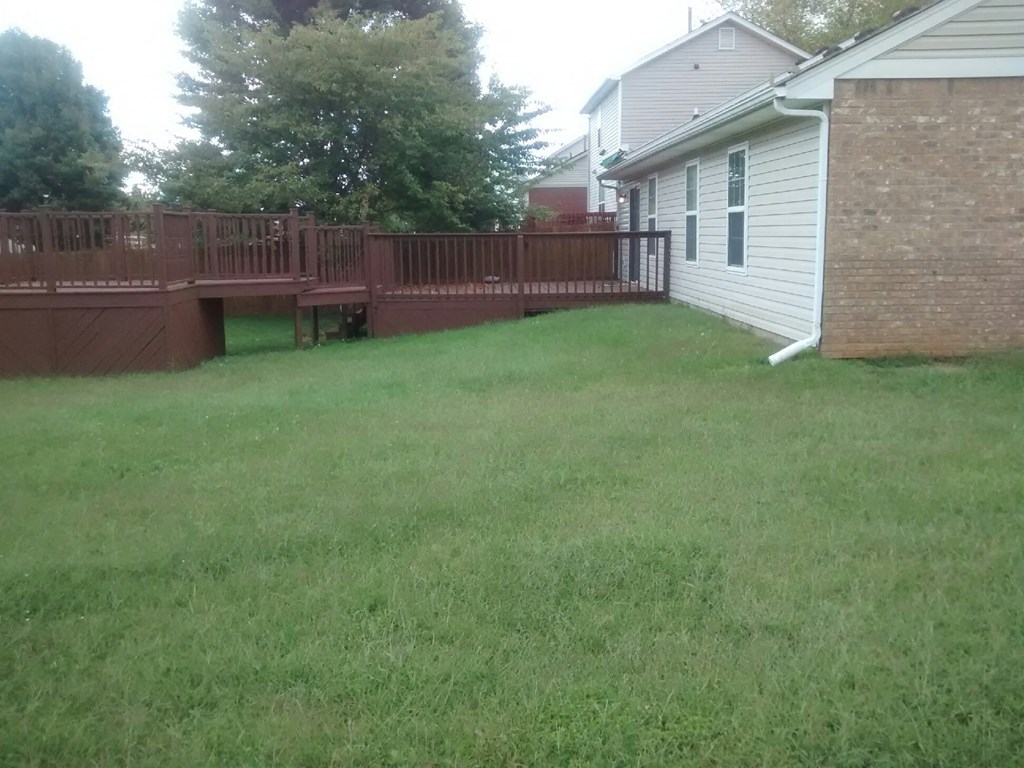 a backyard with a deck and a fence