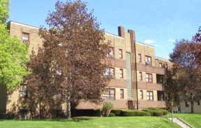a large brick building with trees in front of it