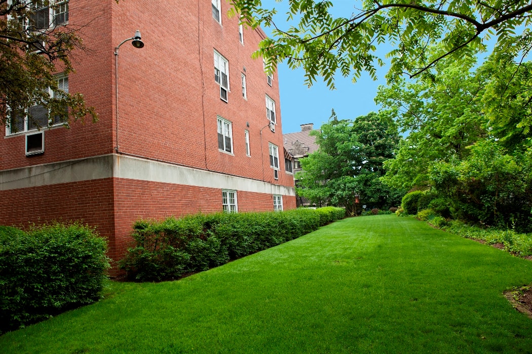 a green lawn in front of a brick building