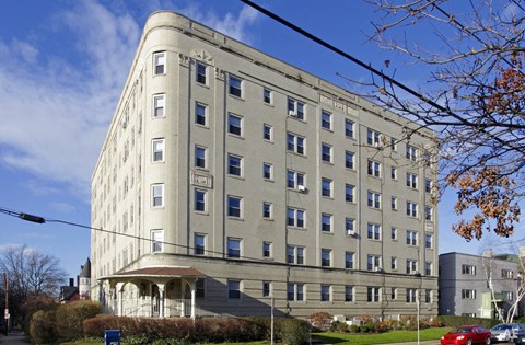 a large building on a city street with a blue sky