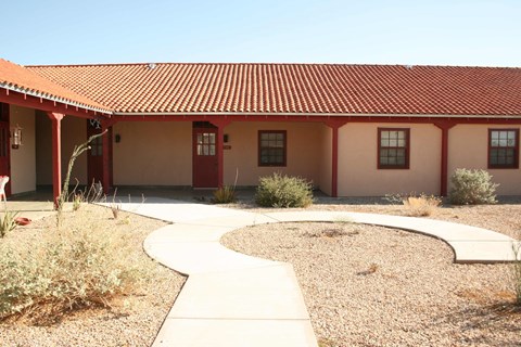 a building with a sidewalk and a red roof
