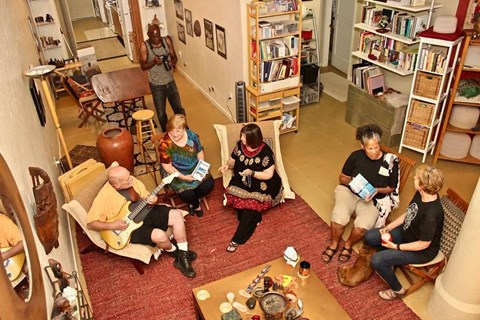 a group of people sitting in a living room playing music