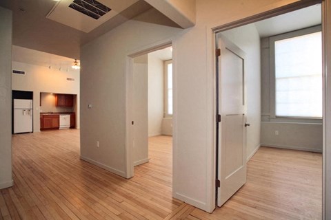 the living room and kitchen of an empty house with a wood floor