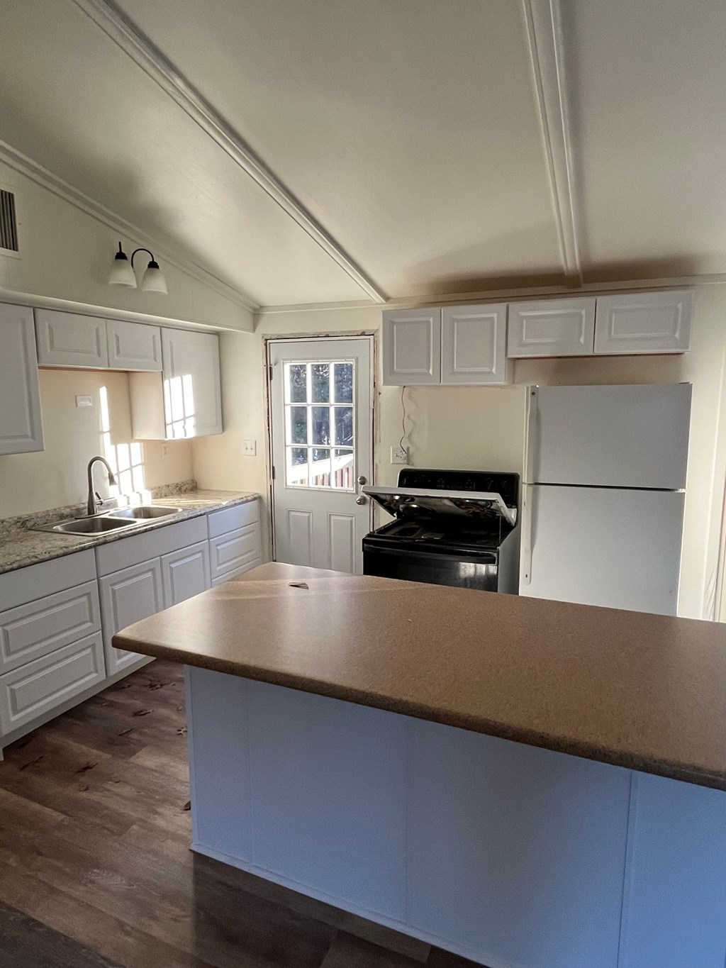 A kitchen with a white fridge and a wooden counter.