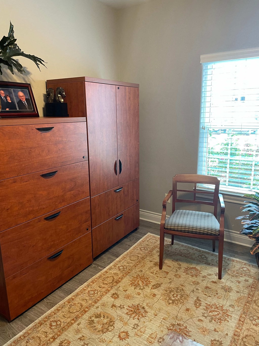 a dresser and a chair in a room with a window