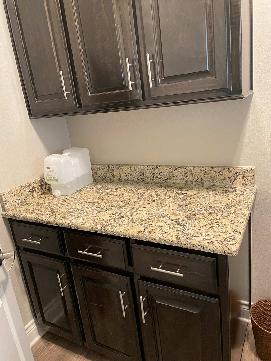 a kitchen with black cabinets and granite counter top and a sink