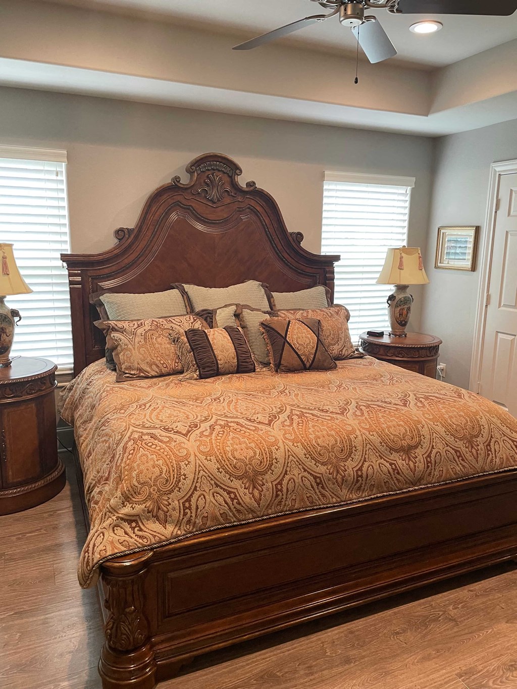 a bedroom with a bed and two lamps and a ceiling fan