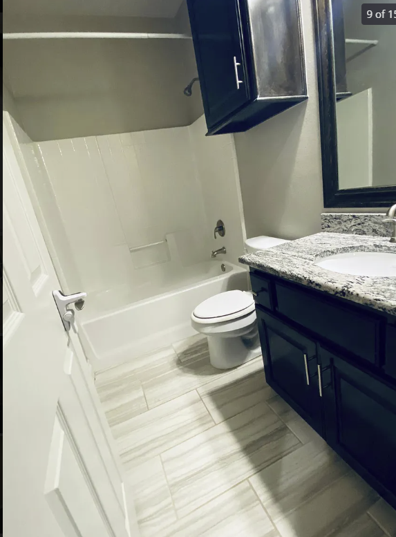 a bathroom with a toilet and a tub and a sink