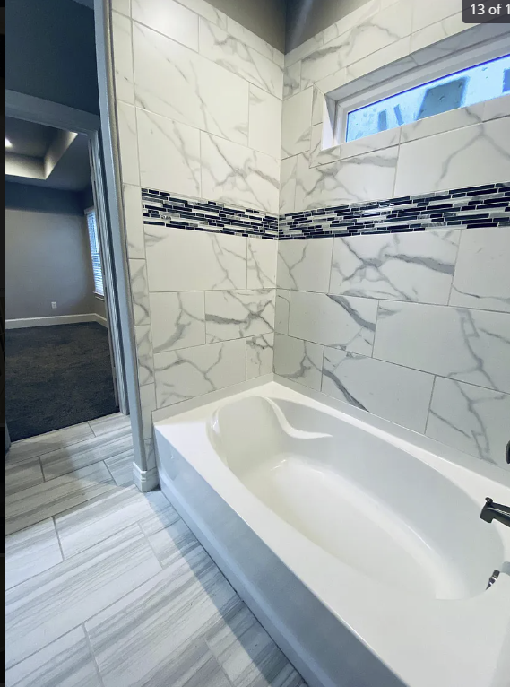 a bathroom with a large tub and a window