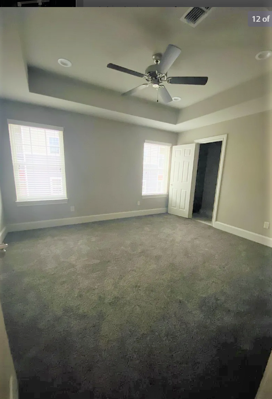 an empty living room with a ceiling fan