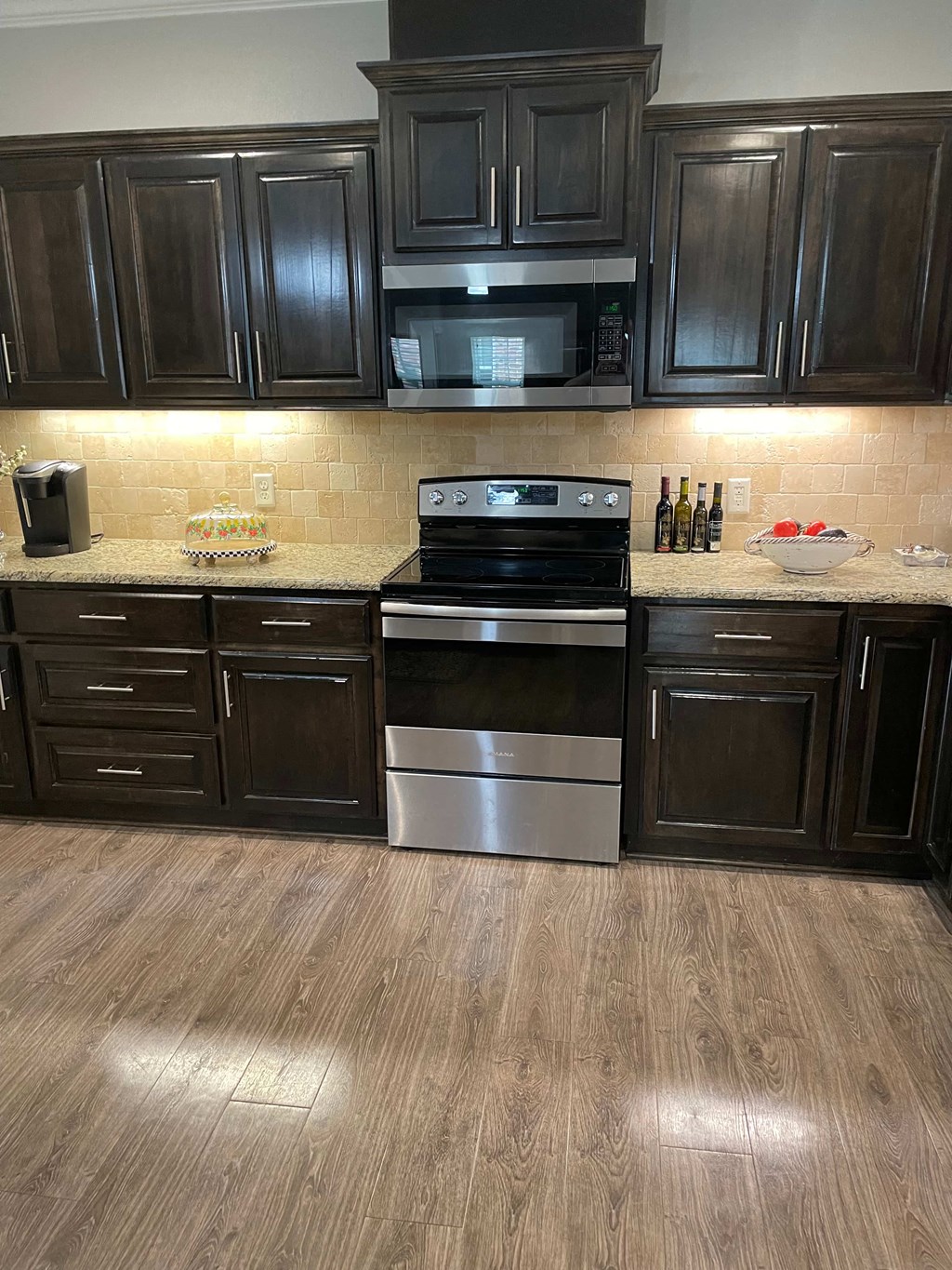 a kitchen with black cabinets and stainless steel appliances
