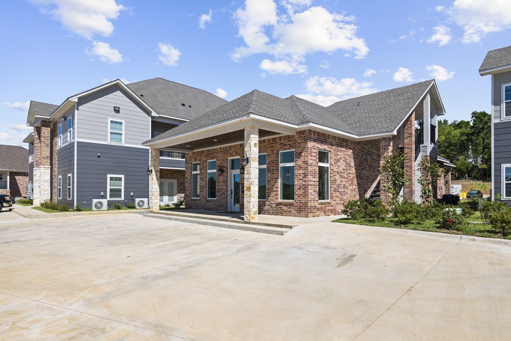 an empty driveway in front of a brick house