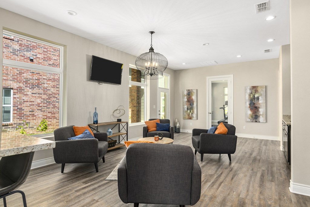a living room with chairs and a table and a television