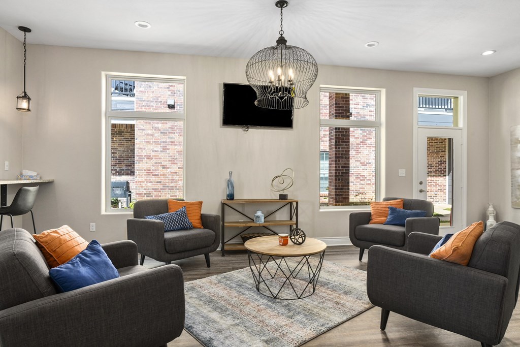 a living room with couches and chairs and a tv