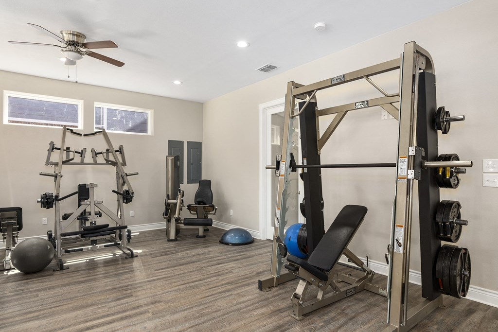 a home gym with exercise equipment and a ceiling fan