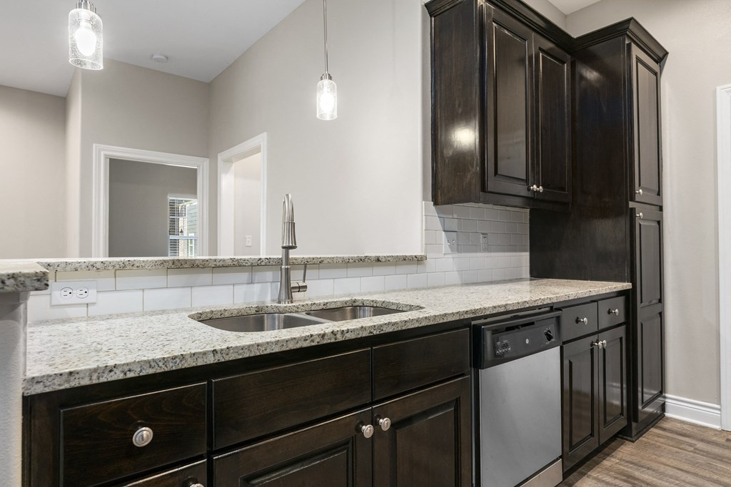 an empty kitchen with a sink and a counter top