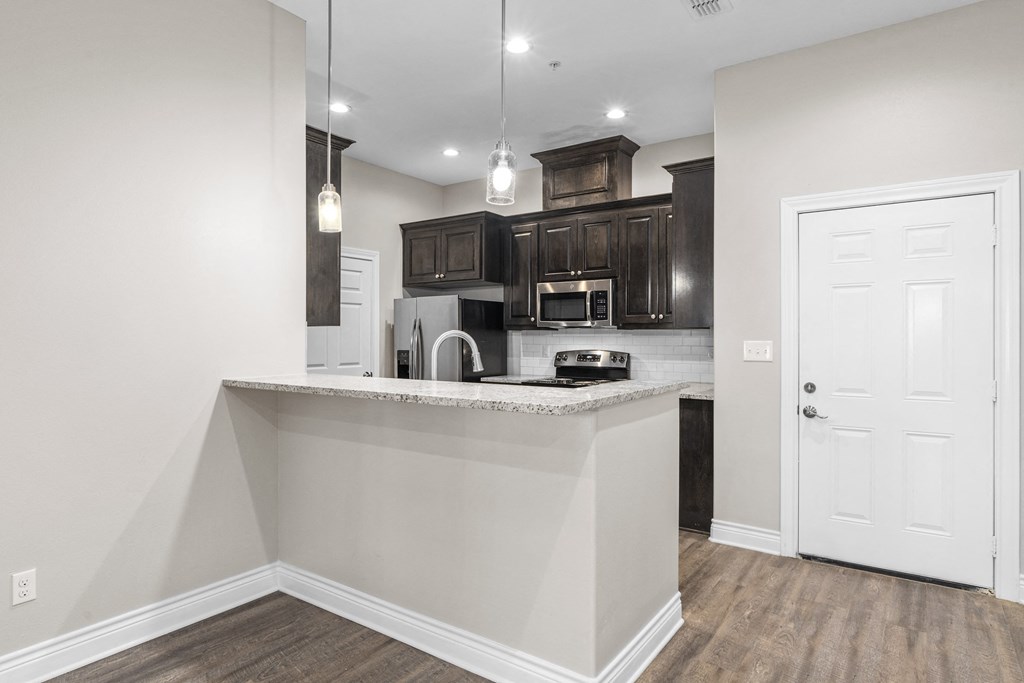 a kitchen with an island and a door to the living room