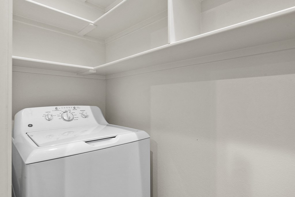 an empty laundry room with a washer and dryer