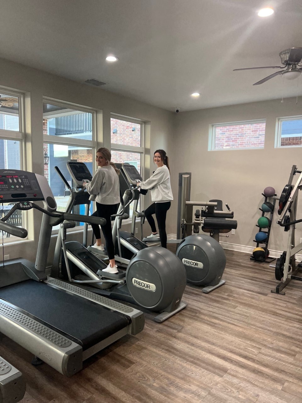 two women running on treadmills in a gym