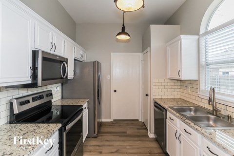 A kitchen with a black stove top oven and a black microwave.