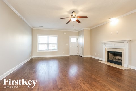 A spacious room with a fireplace and a ceiling fan.