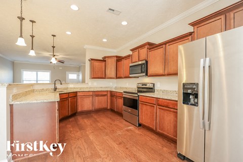 A kitchen with wooden cabinets and a stainless steel refrigerator.
