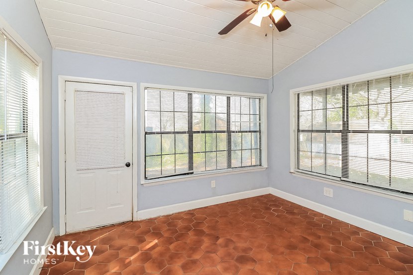the living room of an empty house with windows and a ceiling fan