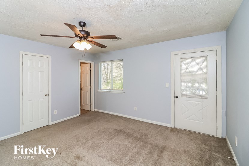 a bedroom with blue walls and a ceiling fan and a door
