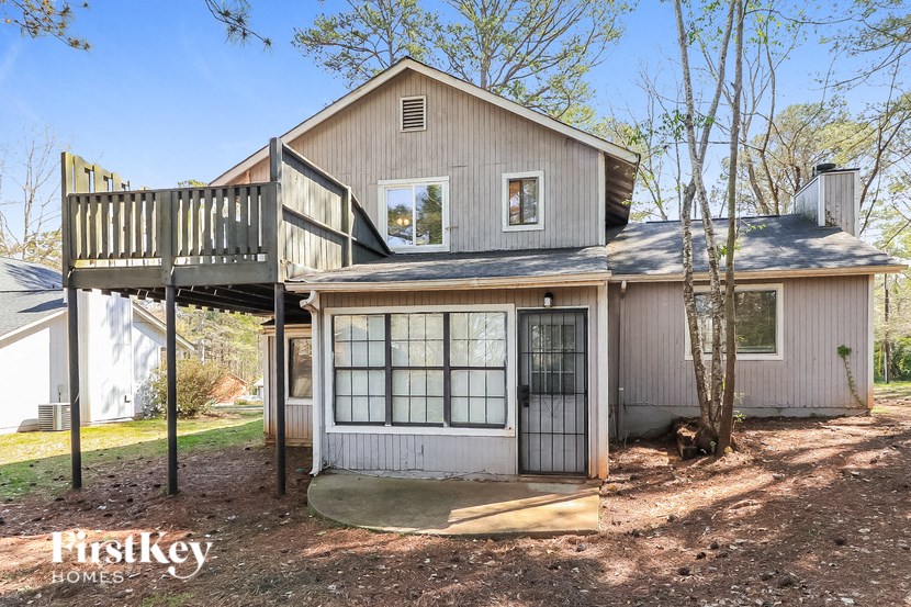 the front of a house with a deck and a staircase