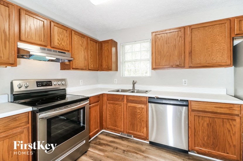 A kitchen with wooden cabinets and a stainless steel dishwasher.
