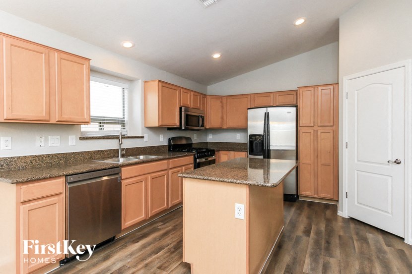 A kitchen with wooden cabinets and a refrigerator.